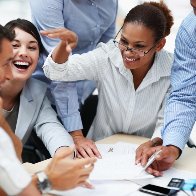 Happy and successful team of colleagues sitting together to work out business plans